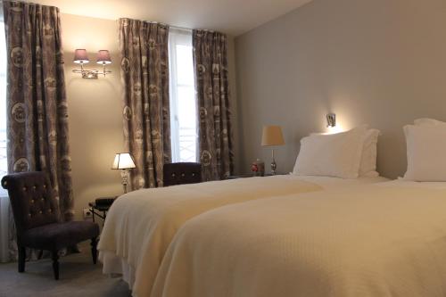 a bedroom with a large white bed and a window at My Home In Paris in Paris