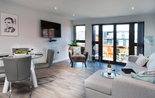 a living room with a couch and a table at Cotels 7Zero1 Aparthotel - Unique Apartment building with friendly Reception - Sky Movies & Sports - Fitness Equipment in Apt - Pet Friendly - Private Garden Area in Milton Keynes