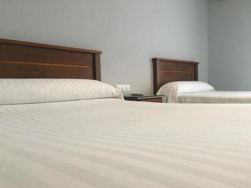 a bedroom with two beds with white sheets at Hotel Santa Fe in Santa Fe