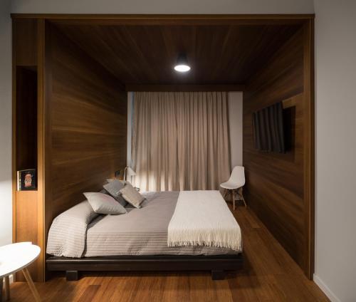a bedroom with a large bed with a wooden headboard at Welldone Antiquarium in Seville