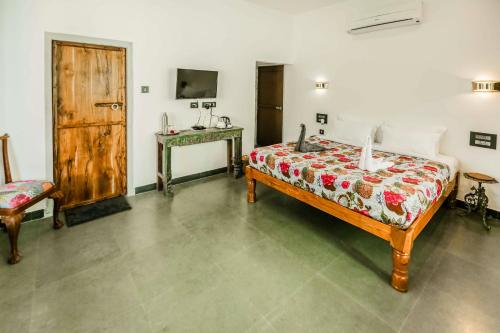 a bedroom with a bed and a table with a telephone at The Neem Tree in Udaipur