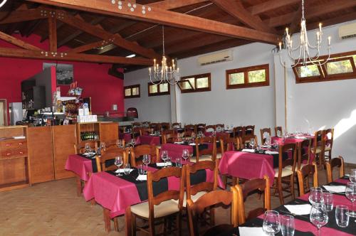 un comedor con mesas y sillas con servilletas rosas en Camping La Estanca, en Alcañiz