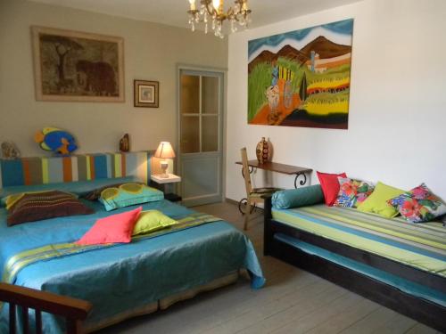 a bedroom with two beds and a painting on the wall at Le Logis d'ANTIGNY in Val-du-Mignon