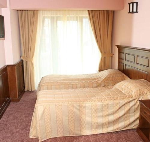 a bedroom with a large bed with a window at Hanul Bran in Bran