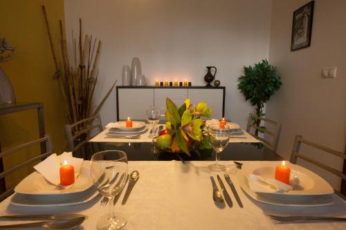 a table with plates and glasses and candles on it at Casa da Horta Açores in Ponta Delgada