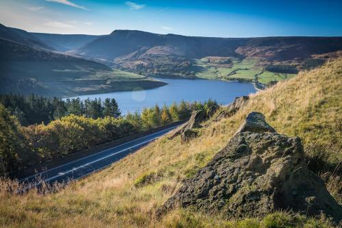 a mountain road with a lake in the background at The Saddleworth Hotel in Diggle