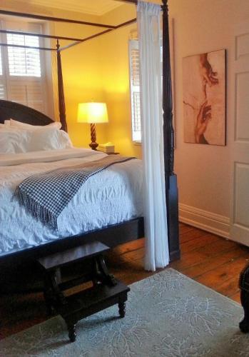 a bedroom with a large bed with a canopy at Plantation House Bed & Breakfast in Port Hope