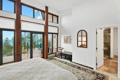 a bedroom with white walls and large windows at Black Rock Ridge in Ucluelet