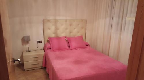 サロウにあるSalou Turisticoのピンクのシーツと枕が備わるベッドルーム1室