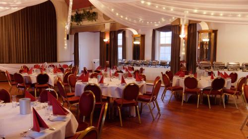 a banquet hall with tables and chairs with red napkins at Gross Bultener Hof in Peine