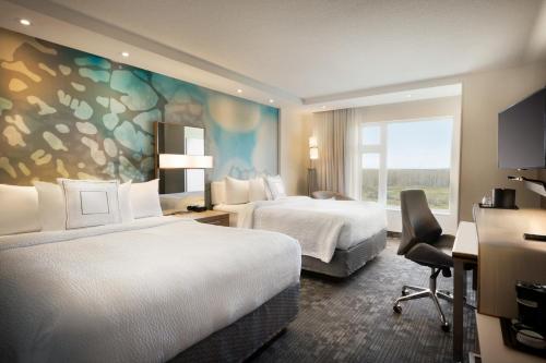 um quarto de hotel com duas camas e uma janela em Hotel Dene & Conference Centre em Cold Lake