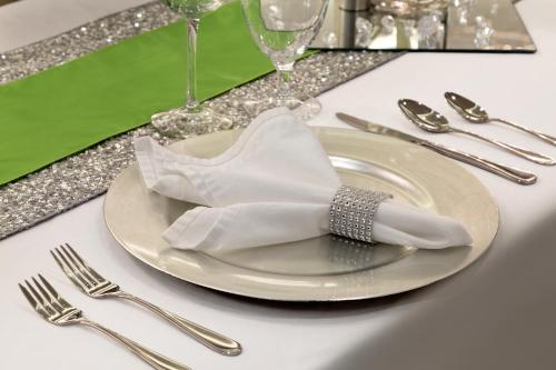 Un plato blanco con una servilleta, un tenedor y un cuchillo. en Hotel Dene & Conference Centre, en Cold Lake
