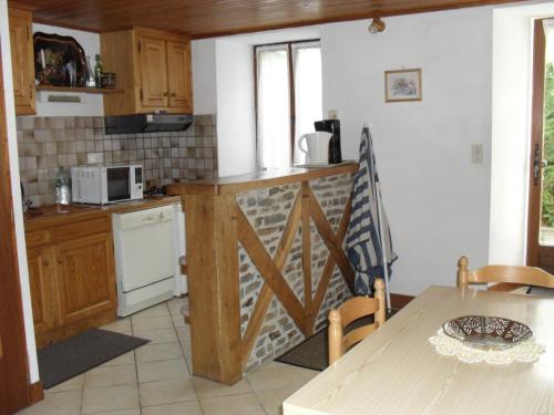 cocina con encimera de madera y mesa con sidra de mesa en appartement vacances à la montagne RDC en Génos