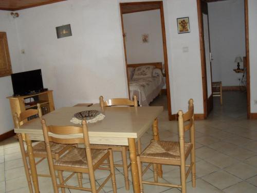 ein Esszimmer mit einem Tisch und Stühlen sowie ein Schlafzimmer in der Unterkunft appartement vacances à la montagne RDC in Génos