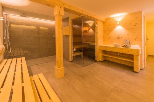 a bathroom with a shower and a bench and a sink at Landhaus Kitzhorn in Kitzbühel