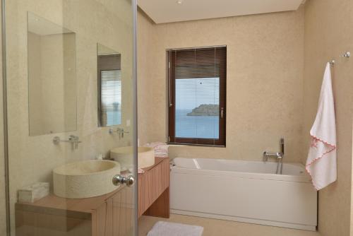 a bathroom with a tub and a sink and a mirror at Villa Danae by Elounda Island View Villas in Elounda