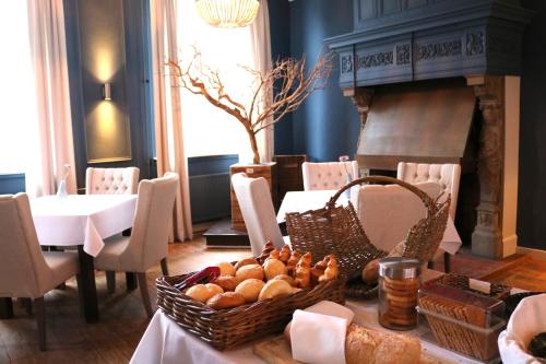 - une table avec un panier de pain et une cheminée dans l'établissement Hotel Kasteel Doenrade, à Doenrade