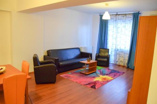 a living room with a black couch and a table at West Gate Studios in Bucharest