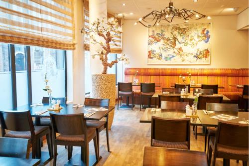 une salle à manger avec des tables et des chaises dans un restaurant dans l'établissement Amrâth Grand Hotel Frans Hals, à Haarlem