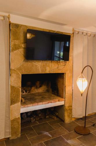 a stone fireplace with a television on top of it at ALEHUE Casa de Montaña in Villa La Angostura