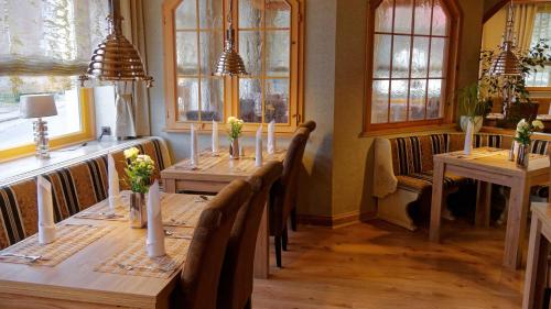 a dining room with a long table with chairs and windows at Gross Bultener Hof in Peine