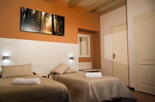a room with two beds and a painting on the wall at Torre di Renda in Piazza Armerina