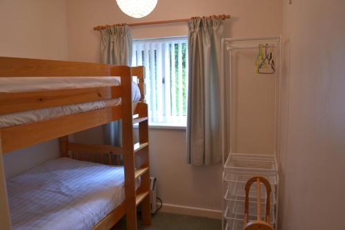 トーキーにあるAppletree Bungalowのベッドルーム1室(二段ベッド2台、窓付)が備わります。