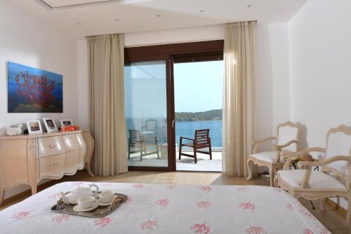 a bedroom with a bed and a view of the ocean at Villa Danae by Elounda Island View Villas in Elounda