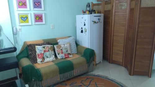 een woonkamer met een bank en een koelkast bij Loft da Prainha Arraial do Cabo in Arraial do Cabo