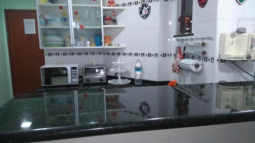 een keuken met een aanrecht met een magnetron bij Loft da Prainha Arraial do Cabo in Arraial do Cabo