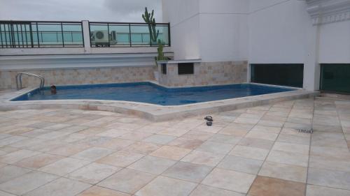 een zwembad in een kamer met een tegelvloer bij Loft da Prainha Arraial do Cabo in Arraial do Cabo