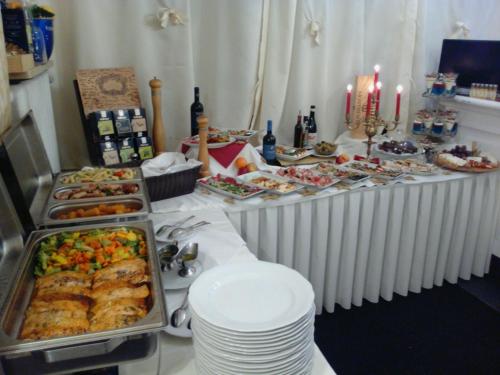 a buffet table with many different foods and candles at Elbhotel Bleckede am Hafen in Bleckede