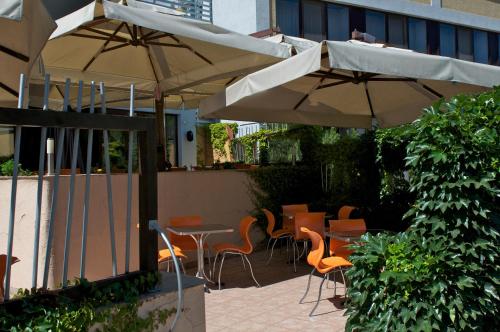 an outdoor patio with tables and chairs and umbrellas at Uliss in Odesa