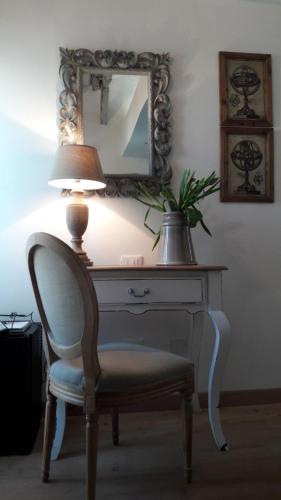a desk with a chair and a lamp and a mirror at Le Stanze del Cardinale in Pavia