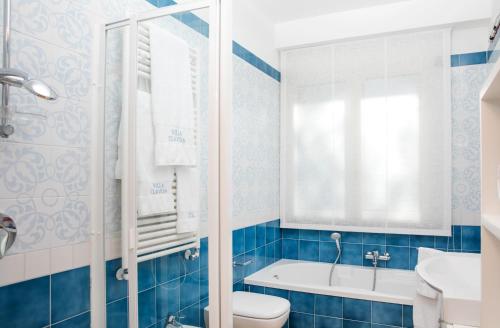 a bathroom with a tub and a toilet and a sink at Villa Claudia in SantʼAgata sui Due Golfi