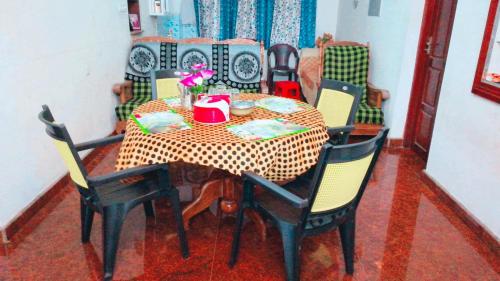 a dining room table with a checkered table and chairs at Takashi Homestay North Paravur Near Muziris in North Paravur