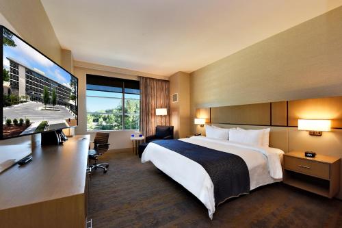 a hotel room with a bed and a flat screen tv at JB Duke Hotel in Durham