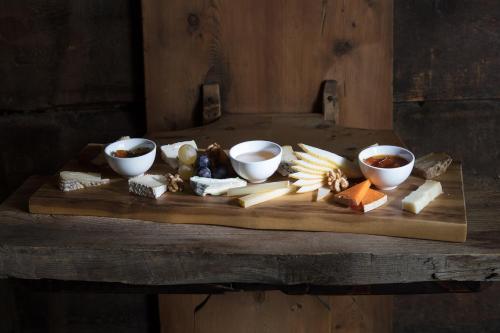 a wooden cutting board with different types of cheese on it at Camana Veglia in Livigno