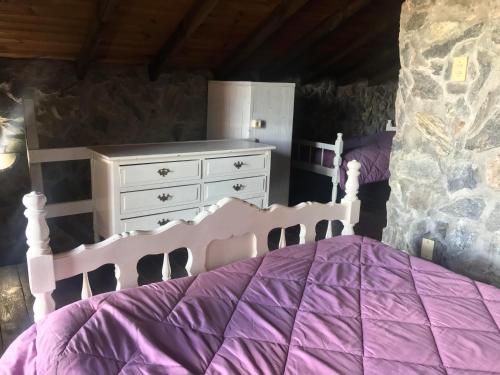 a bedroom with a purple bed and a dresser at San Francisco De Las Sierras in Minas