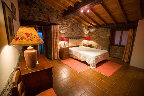 una camera da letto con un letto e un tavolo con una lampada di Casa do Pomar a Bragança