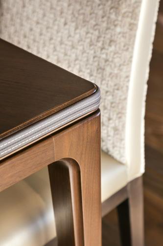 a wooden table and a white chair next to a desk at Guarda Golf Hotel & Residences in Crans-Montana