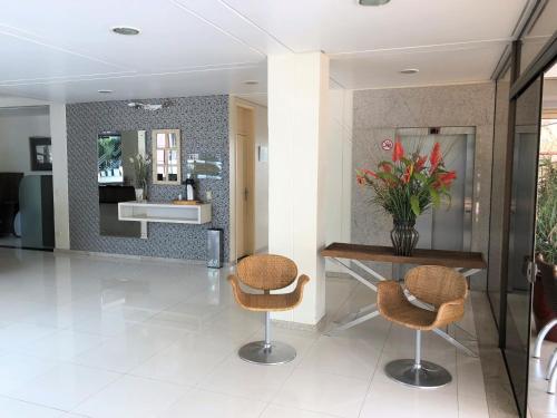a hallway with two chairs and a table and a mirror at Hotel 2 Gauchos in Naviraí