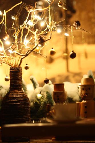 a table with a vase with a tree with lights at Pension Hotel Sartor in Kurort Altenberg
