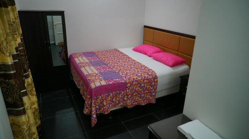 a bedroom with a bed with two pink pillows at MRI Residence - Homestay in Sg Buloh with Swimming Pool - No Pork&Alcohol Allowed in Bandar Puncak Alam