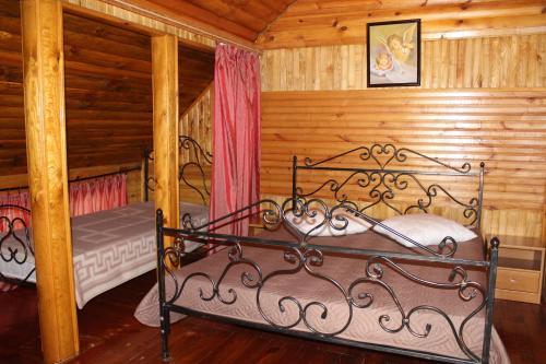 a bedroom with two beds in a log cabin at Hotel-complex Mizh Triokh Ozer in Svityazʼ