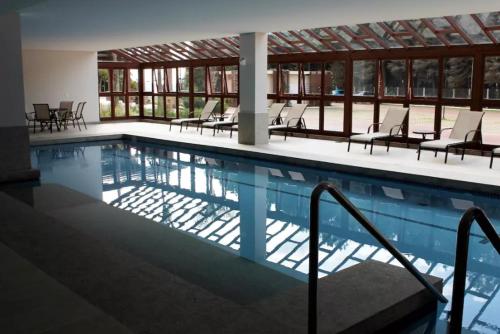 a large swimming pool with chairs and tables at Flat em Vista Azul Hotel in Pedra Azul