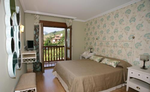 a bedroom with a bed and a balcony at Posada El Corcal de Liébana in Tama