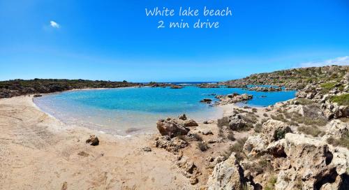 a view of a beach with blue water and rocks at White Lake Holiday House in Elafonisi