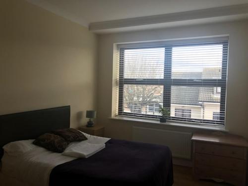 1 dormitorio con cama y ventana grande en slough central - spacious 2 bedroom, 2 bathroom apartment, en Slough