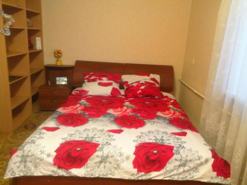 トムスクにあるКвартира в ЦЕНТРЕ на проспекте Ленинаのベッドルームに赤いバラのベッド
